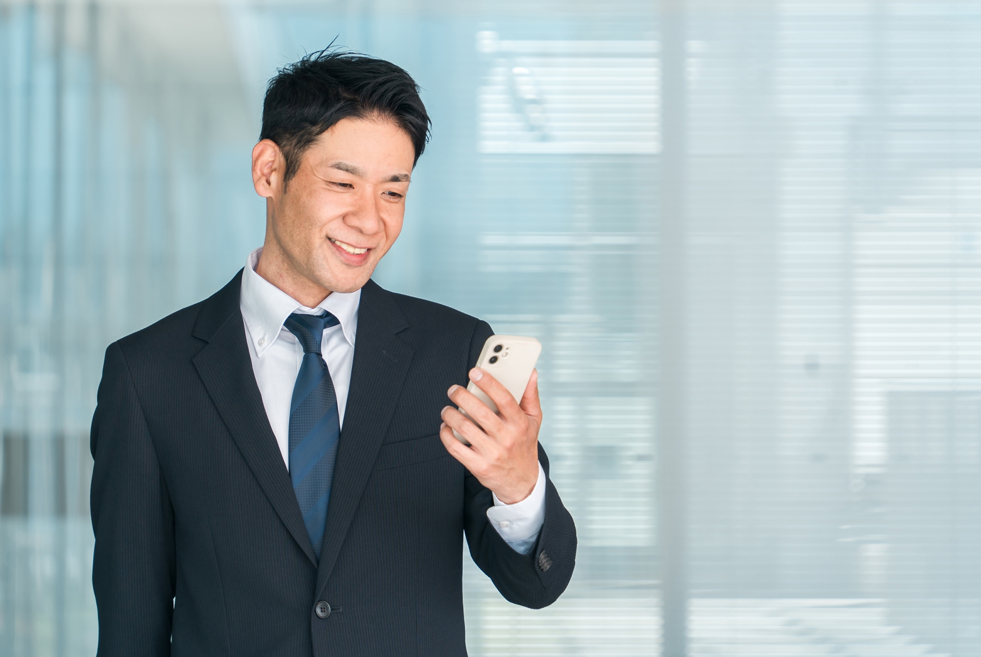 スーツ姿の男性がスマホを操作