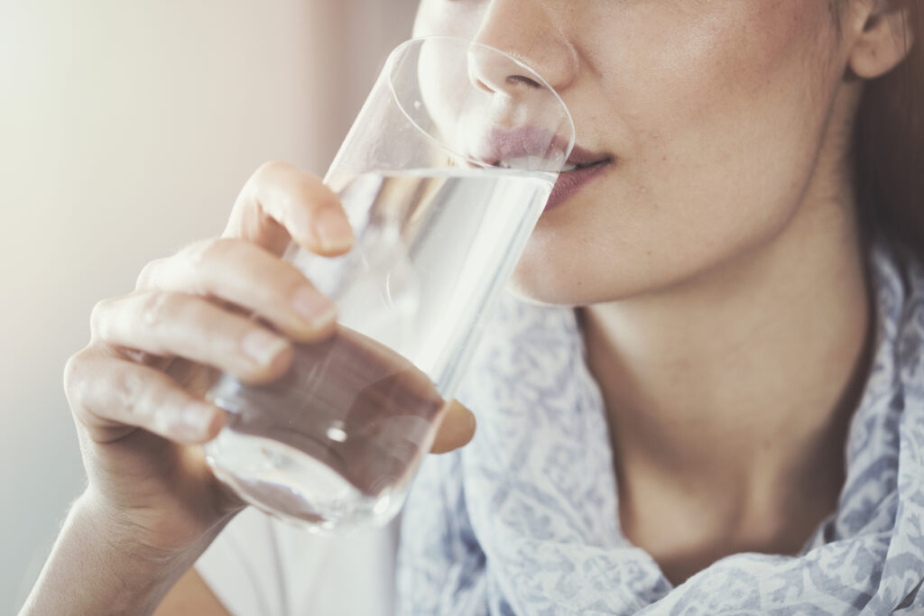 グラスで水を飲む女性